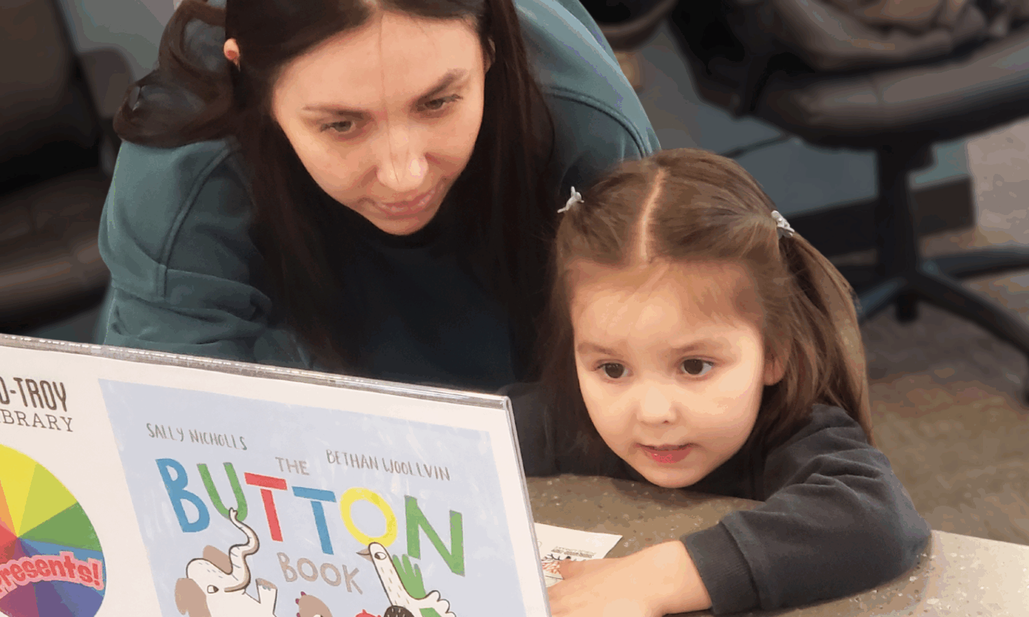 Mom and child intently reading library material