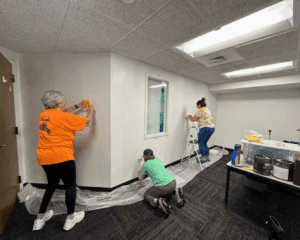 Three ladies prepping and priming the walls