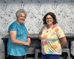 Friends Jeanne and Valerie posing in front of the accent wall